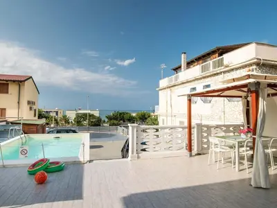 a patio with a pool and a table and chairs at Apartment in Alcamo near the Beach in Alcamo Marina