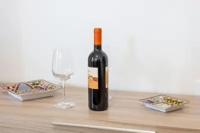 a bottle of wine and a glass on a table at Villa Alma in Campofelice di Roccella