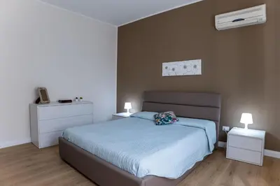a bedroom with a bed and two night stands with lamps at Villa Alma in Campofelice di Roccella