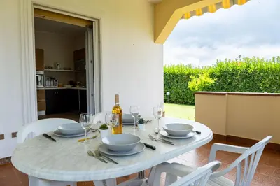 a white table with chairs and a bottle of wine at Villa Alma in Campofelice di Roccella