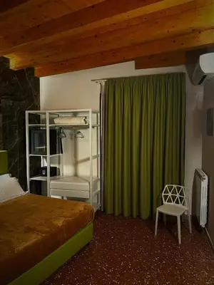 a bedroom with a bed and a green curtain at Abside Suite & Spa in Palermo