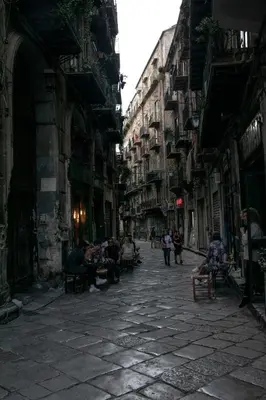 a group of people sitting on benches in an alley at Abside Suite & Spa in Palermo