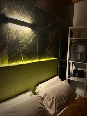 a bedroom with a bed with a green headboard at Abside Suite & Spa in Palermo