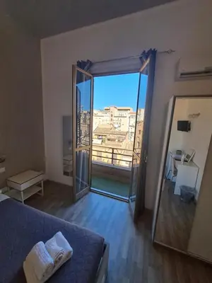 a bedroom with a large glass door leading to a balcony at Bedroom la stazione in Palermo