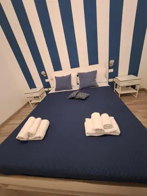 a blue bed with towels and pillows on it at Bedroom la stazione in Palermo