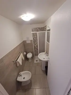 a bathroom with two sinks and a toilet and a shower at Bedroom la stazione in Palermo