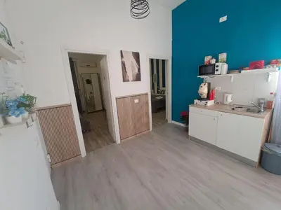 a room with a kitchen and a blue wall at Bedroom la stazione in Palermo