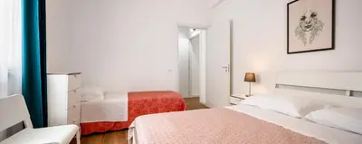 a white bedroom with two beds and a window at Arricàmpati Villa & Bringo Car Rental in Carini