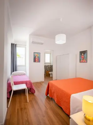 a white room with two beds and a table at Arricàmpati Airport Rooms in Villa & RENT CAR in Carini
