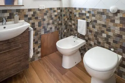 a bathroom with a toilet and a sink at Arricàmpati Airport Rooms in Villa & RENT CAR in Carini
