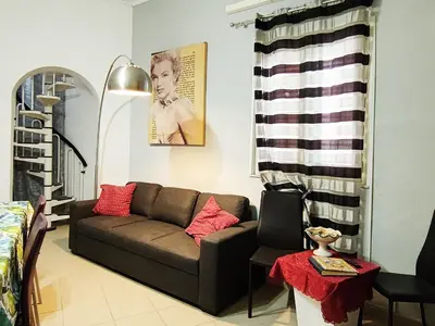 a living room with a couch and a chair at Guastella House in Palermo