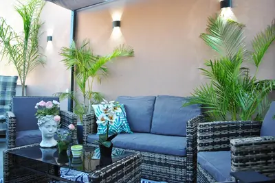 a patio with a blue couch and a table at Guastella House in Palermo