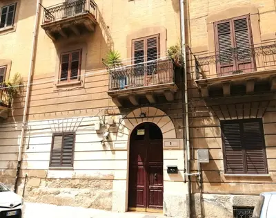 a building with a door and balconies on it at Guastella House in Palermo