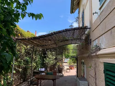 a patio with a table and a wicker archway at mondello beach luxury apartments in Palermo