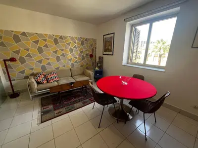 a living room with a red table and a couch at home.70 Carini in Palermo