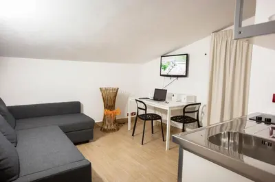 a living room with a couch and a table with a laptop at B&B Kòre in Castellammare del Golfo