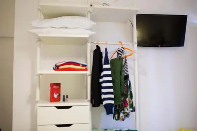 a room with a closet with a tv and towels at B&B Kòre in Castellammare del Golfo
