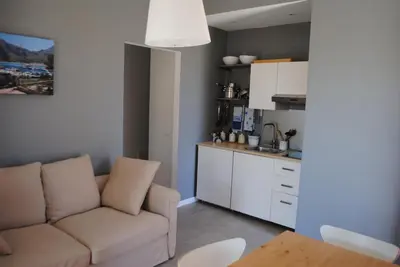 a living room with a couch and a kitchen at Villa Smeralda in San Vito lo Capo