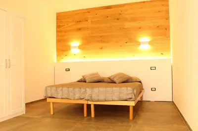 a bed in a room with a wooden ceiling at Sicilia d'Amare in Capaci