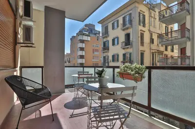 a balcony with a table and chairs and a view of the water at Libertà Central Suites in Palermo