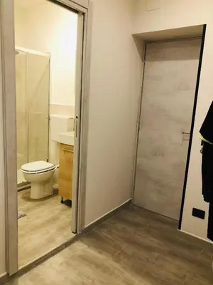 a bathroom with a toilet and a glass shower door at Dal Barce Rooms in Palermo