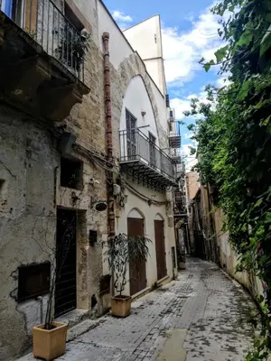 an alley in an old town with a building at Arimatea Casa Vacanza in Palermo