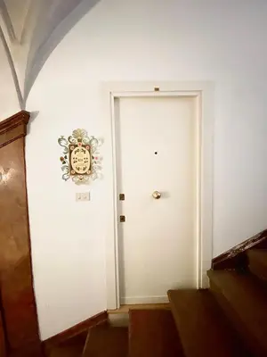 a white door with a crest on the wall at Case Natoli - Residenze d'Epoca in Palermo