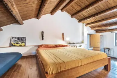a bedroom with a large bed and wooden ceilings at Historical Penthause Ballarò with view in Palermo