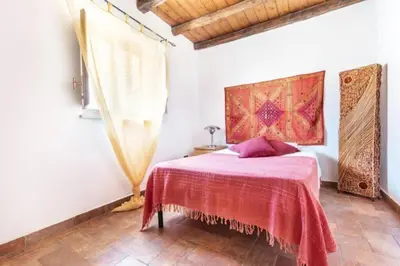 a bedroom with a bed with a red blanket at Historical Penthause Ballarò with view in Palermo