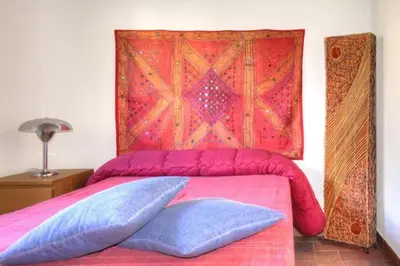 a bed with two pillows on top of it with a blanket at Historical Penthause Ballarò with view in Palermo