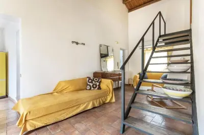 a living room with a yellow couch and a staircase at Historical Penthause Ballarò with view in Palermo