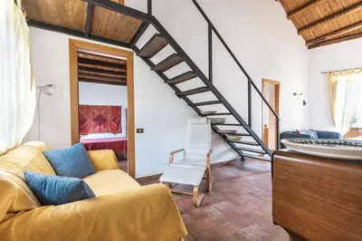 a living room with a couch and a staircase at Historical Penthause Ballarò with view in Palermo