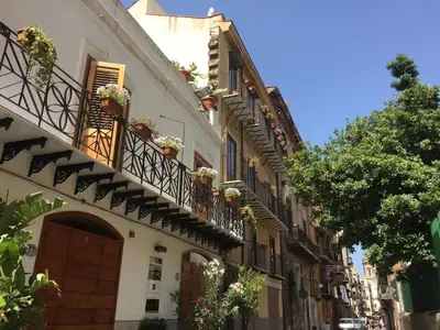 an alley with potted plants on the balconies of buildings at Historical Penthause Ballarò with view in Palermo