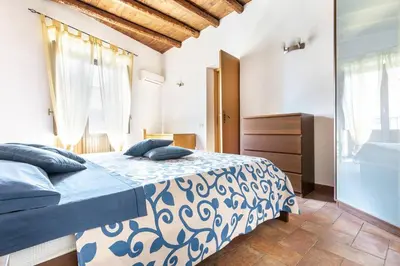 a bedroom with a bed with blue and white sheets at Historical Penthause Ballarò with view in Palermo