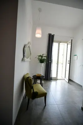 a living room with a yellow chair and a table at Inkantu B&B in Terrasini