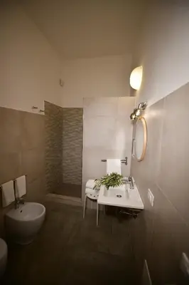 a bathroom with a sink and a toilet and a tub at Inkantu B&B in Terrasini