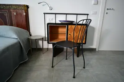 a table with a chair next to a bed at Inkantu B&B in Terrasini