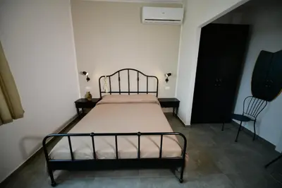 a bedroom with a bed and a chair at Inkantu B&B in Terrasini