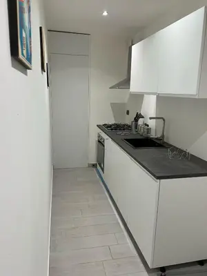 a white kitchen with a sink and a stove at Villa DANAE in Mondello