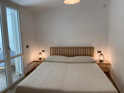 a bedroom with a large bed and two lamps on tables at Villa DANAE in Mondello