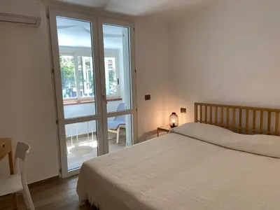 a bedroom with a bed and a sliding glass door at Villa DANAE in Mondello