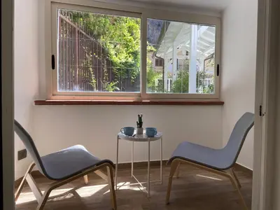 two chairs and a table in a room with a window at Villa DANAE in Mondello