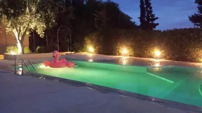a swimming pool at night with a pink float in it at Villa Flore - Penthouse - apartment in villa in Casteldaccia