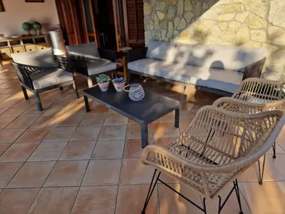 a living room with chairs and a couch and a table at Villa del Carrubo a due passi dal mare di Cefalù in Collesano