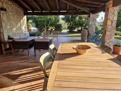 a wooden table and chairs on a patio at Villa del Carrubo a due passi dal mare di Cefalù in Collesano