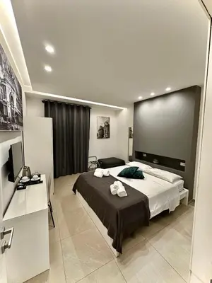 a bedroom with a large bed with a large screen at Suites Central Station in Palermo