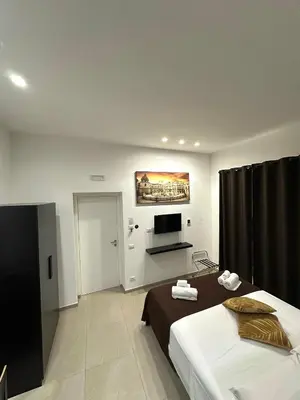 a hotel room with a bed and a television at Suites Central Station in Palermo