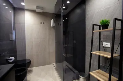 a bathroom with a shower with a glass door at Suites Central Station in Palermo
