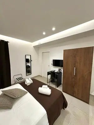 a bedroom with a large bed and a desk at Suites Central Station in Palermo