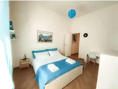 a bedroom with a blue bed with towels on it at Lucky Inn, La Locanda della Fortuna in Palermo
